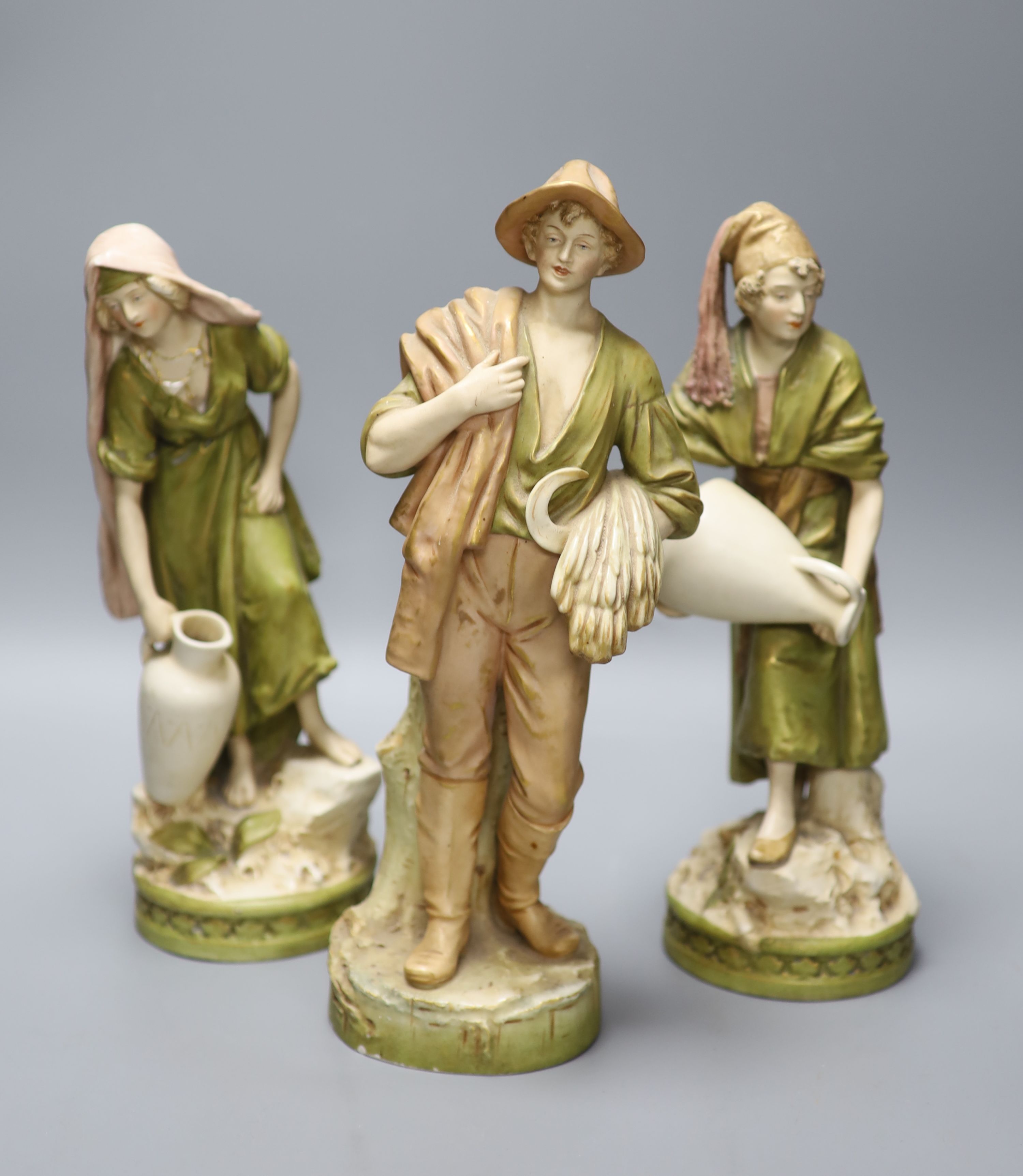 A pair of Royal Dux female water carriers and another of a farmer, 32cm